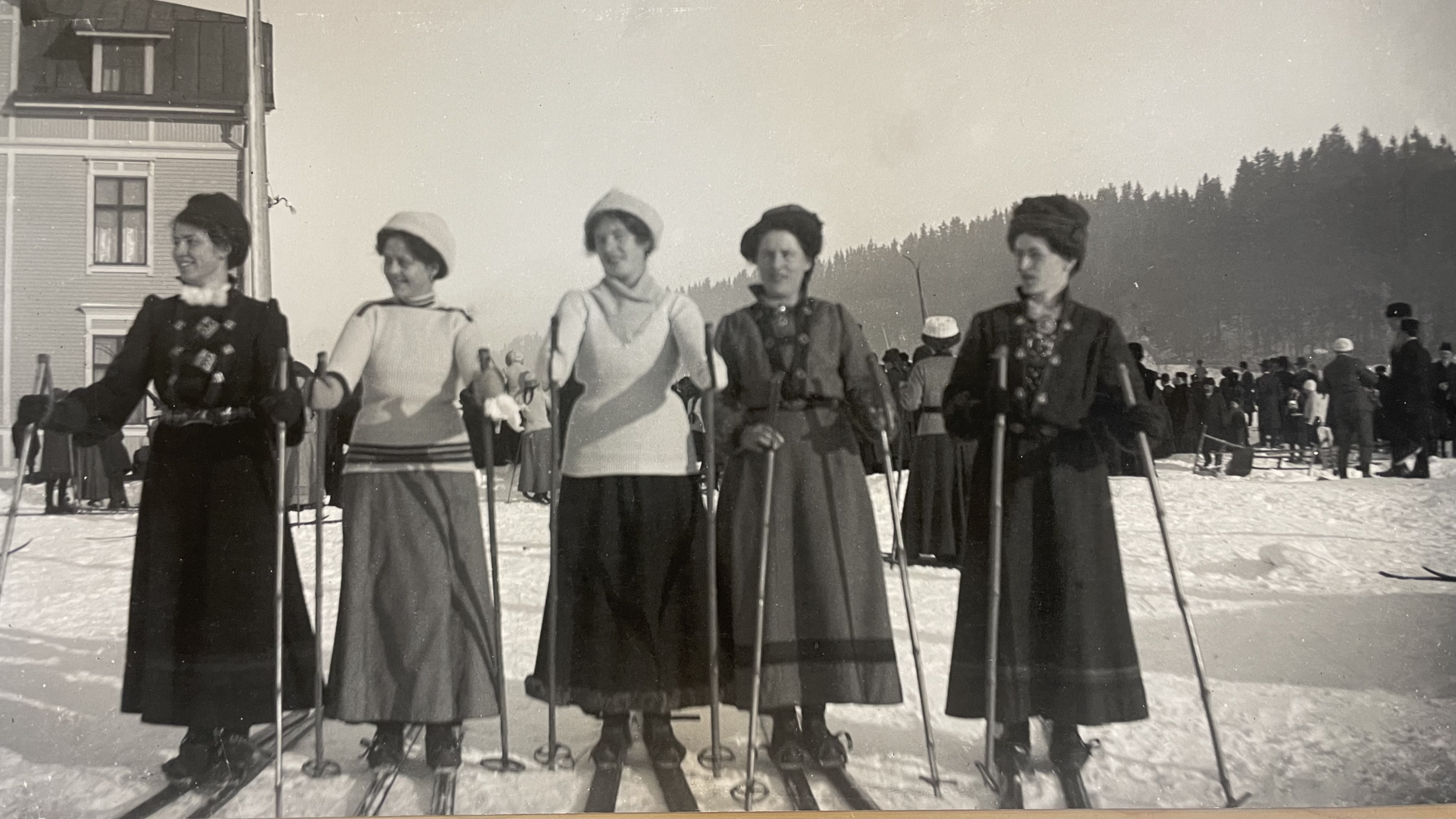 Svartvitt fotografi av fem kvinnor som ska åka skidor Svartvitt fotografi av fem kvinnor som ska åka skidor